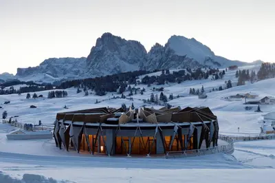 a snow covered mountain in front of a snow covered slope at COMO Alpina Dolomites in Alpe di Siusi