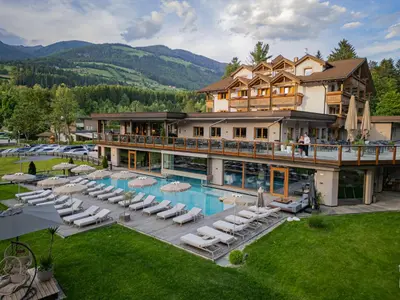 an aerial view of a hotel with a pool and lounge chairs at Hotel Weiher Green Lake in Falzes