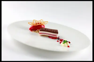 a white plate with two pieces of dessert on it at Hotel Weiher Green Lake in Falzes