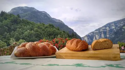 three loaves of bread sitting on cutting boards on a table at Eco-Baita Natura Spensierata in Canale San Bovo