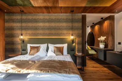 a bedroom with a large bed and wooden walls at Ladinia Dolomites View - Adults Only in Pozza di Fassa