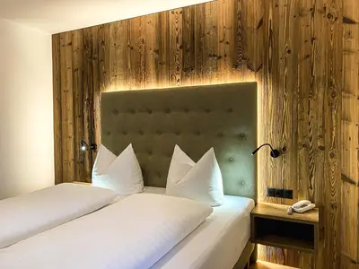 two beds with white pillows in a hotel room at Residence Garni Melcherhof in Racines