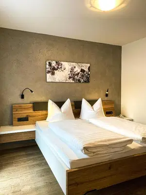 a bedroom with a large bed with white sheets at Residence Garni Melcherhof in Racines
