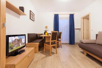 a living room with a couch and a table with a television at Residence Garni Melcherhof in Racines