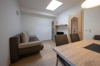 a living room with a dining room table and chairs at Residence Garni Melcherhof in Racines