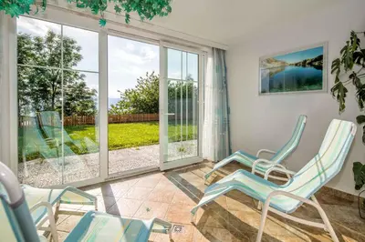 a living room with two chairs and a large window at Residence Rossboden mit Hallenbad in Verano