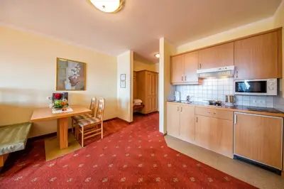 a kitchen with a table and a dining room at Residence Rossboden mit Hallenbad in Verano