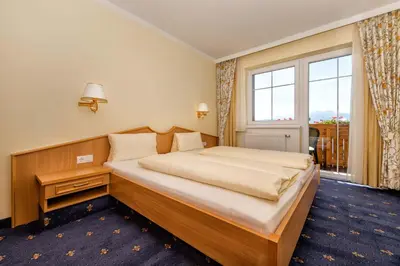 a bedroom with a large bed and a large window at Residence Rossboden mit Hallenbad in Verano