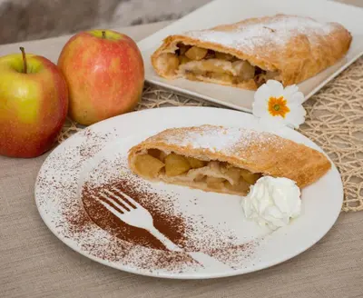 a plate with a pie and two apples on a table at Maso Franceschella in Carano