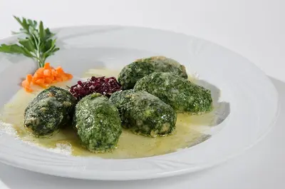 a plate of food with meatballs and vegetables on it at Hotel Aida in Pozza di Fassa