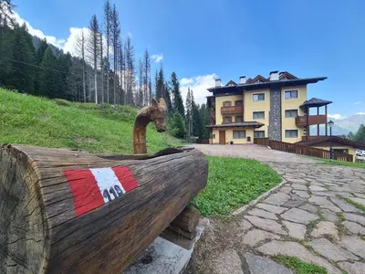 a ski lodge in the mountains with snow covered trees at Residence Panorama in Falcade