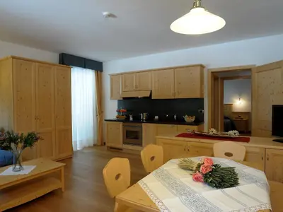 a bedroom with a bed and a table and windows at Residence Panorama in Falcade