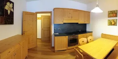 a bathroom with a shower and two sinks and a toilet at Residence Panorama in Falcade