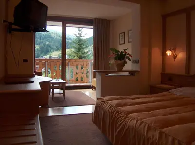 a hotel room with a bed and a balcony at Hotel Catinaccio Rosengarten in Moena