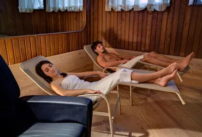 three people laying in chairs in a room at Hotel Catinaccio Rosengarten in Moena
