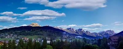 a town in a valley with mountains in the background at Hotel Catinaccio Rosengarten in Moena