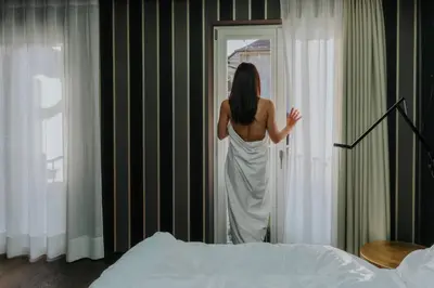 a woman in a white dress looking out of a door at Guesthouse Suiteseven in Merano