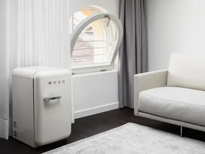 a room with a small refrigerator next to a window at Guesthouse Suiteseven in Merano