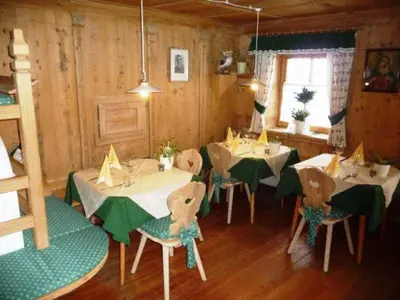 a dining room with tables and chairs in a cabin at Berggasthaus Agritur Moserhof in Braies