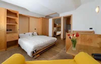 a bedroom with a bed and a table with flowers at Residence Miramonti in Daiano