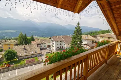 a balcony with a view of a town and mountains at Residence Miramonti in Daiano
