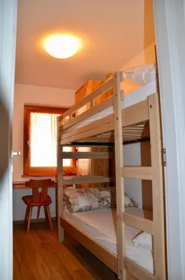 a bedroom with a bed and two lamps on tables at Casa del bosco in Canazei