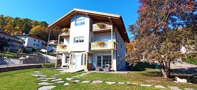 a white house with a gambrel roof at Alla Fontana Termale in Carano