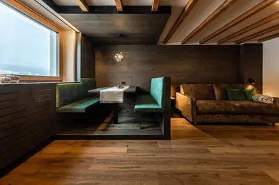 a dining room with a table and a couch at Apartments Ursus in San Cassiano
