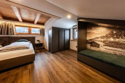 a bedroom with a bed and a painting on the wall at Apartments Ursus in San Cassiano