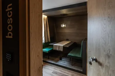 a dining room with a table and green chairs at Apartments Ursus in San Cassiano