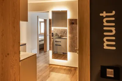a kitchen with a door leading into a room at Apartments Ursus in San Cassiano