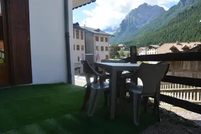 a table and chairs on a balcony with a view at Cèsa Soracrepa in Canazei