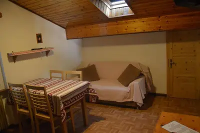 a bedroom with a bed and a table and chairs at Cèsa Soracrepa in Canazei