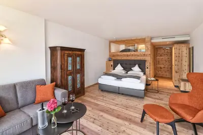 a living room with a bed and a couch at Hotel Ortler in Tirolo