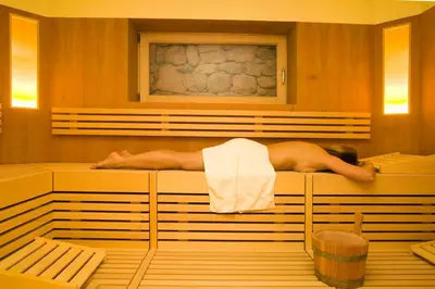 a man laying in a bath tub in a room at Hotel Ortler in Tirolo