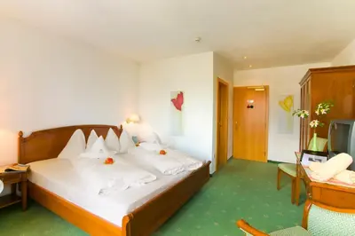 a hotel room with a bed and a television at Hotel Ortler in Tirolo