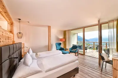 a hotel room with a bed and a balcony at Hotel Ortler in Tirolo