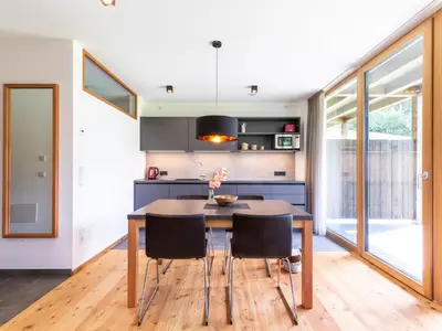 a kitchen with a wooden table and black chairs at KRONPLATZ CHALET WALCHHORN - Brunico, Dolomites in Brunico
