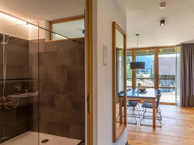 a bathroom with a glass shower and a table at KRONPLATZ CHALET WALCHHORN - Brunico, Dolomites in Brunico
