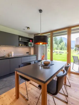 a kitchen with a table and chairs and a large window at KRONPLATZ CHALET WALCHHORN - Brunico, Dolomites in Brunico