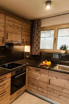 a kitchen with wooden cabinets and a bowl of fruit on the counter at Alpine Chalets App. Pichlerhof in Brunico