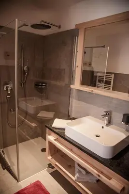 a bathroom with a sink and a shower at Alpine Chalets App. Pichlerhof in Brunico