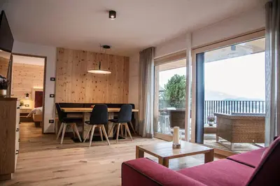 a living room with a table and a dining room at Alpine Chalets App. Pichlerhof in Brunico