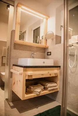 a bathroom with a sink and a mirror at Alpine Chalets App. Pichlerhof in Brunico
