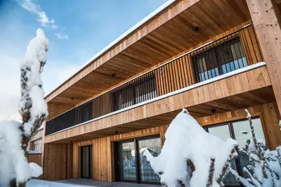 a wooden building with snow on the ground at Alpine Chalets App. Pichlerhof in Brunico