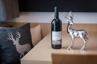 a bottle of wine and a statue of a deer on a table at Appartements Bäckhof in Villa Ottone