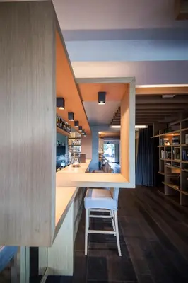 a bar in a kitchen with a chair at a counter at Das Panorama Designhotel in Caldaro