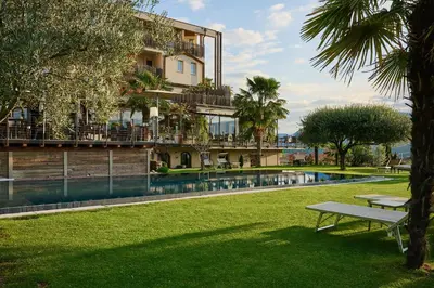 a building with a swimming pool in a park at Das Panorama Designhotel in Caldaro