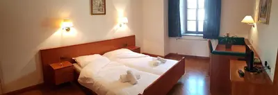 a bedroom with a bed with two towels on it at Weißes Rössl in Appiano sulla Strada del Vino