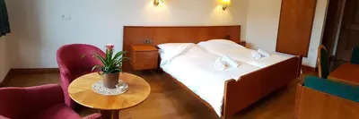 a bedroom with a bed and a table and a chair at Weißes Rössl in Appiano sulla Strada del Vino